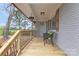 Covered porch with comfortable seating, decorative plants, and new wood flooring at 4566 Fork Rd, Norwood, NC 28128