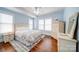 Comfortable bedroom with hardwood floors, a ceiling fan, and blue walls at 501 Pee Dee Ave, Albemarle, NC 28001