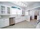 Kitchen featuring a farmhouse sink, granite countertops, stainless steel appliances, and white cabinetry at 501 Pee Dee Ave, Albemarle, NC 28001
