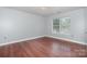 Bedroom with wood floors, neutral walls, and a large window at 5141 Grays Ridge Dr, Charlotte, NC 28269