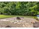 Inviting backyard fire pit with stone and gravel surround, perfect for outdoor entertaining and relaxation at 5229 Mt Holly Huntersville Rd, Charlotte, NC 28216