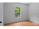 Cozy bedroom with light walls, wood floors and a window view of the exterior at 5229 Mt Holly Huntersville Rd, Charlotte, NC 28216