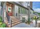 Inviting front porch with brick steps, black railings, a wooden door with wreath, and multiple windows at 536 Hillside Ave, Charlotte, NC 28209