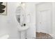 Bathroom features a pedestal sink, round mirror, and is adjacent to another room at 5630 Galloway Dr # 49, Stanfield, NC 28163