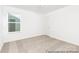 Bright bedroom with neutral carpet, freshly painted white walls, and a window letting in natural light at 5630 Galloway Dr # 49, Stanfield, NC 28163