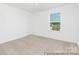 A bedroom featuring neutral carpet, a window letting in natural light, and freshly painted white walls at 5630 Galloway Dr # 49, Stanfield, NC 28163