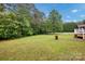 Picture of the grass-covered backyard surrounded by trees and a white fence at 5678 Cedar Run Dr, Denver, NC 28037