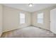 Sunlit bedroom with windows, soft carpeting, and a light-colored door, creating a warm space at 5678 Cedar Run Dr, Denver, NC 28037