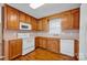 Kitchen featuring wooden cabinets, white appliances, laminate countertops, and hardwood floors at 5678 Cedar Run Dr, Denver, NC 28037