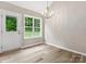 Bright dining room with wood floors, modern chandelier, and natural light streaming through the window at 6022 Windsong Way, Wingate, NC 28174