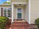 A welcoming front porch with brick steps leads to the front door, offering a cozy entrance at 6022 Windsong Way, Wingate, NC 28174