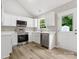Modern kitchen featuring stainless steel appliances, white cabinets and light countertops at 6022 Windsong Way, Wingate, NC 28174