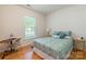 Bright bedroom with hardwood floors features a full bed and desk near the window at 640 Mackenzie Falls Dr, Fort Mill, SC 29715