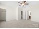 Bright bedroom featuring neutral walls, carpet, ceiling fan, with bathroom and walk-in closet access at 6429 Terrace View Ct, Charlotte, NC 28269