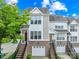 Charming two-story townhome with brick accents, garage, and inviting entryway staircase, framed by a lush green tree at 6429 Terrace View Ct, Charlotte, NC 28269