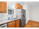Bright kitchen features stainless steel refrigerator, granite countertops, wood cabinets, and a large window at 6429 Terrace View Ct, Charlotte, NC 28269
