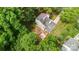 Aerial view of a two-story house with a deck, fire pit, green trees, and grass under a bright, sunny sky at 6824 Cortez Trl, Charlotte, NC 28227