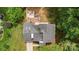 Aerial view of a shingled roof and back yard, including a deck, fire pit, grass, and trees at 6824 Cortez Trl, Charlotte, NC 28227