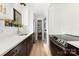 Modern kitchen with stainless steel appliances, white cabinets, and an adjacent laundry area at 6824 Cortez Trl, Charlotte, NC 28227