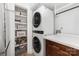 Functional laundry area boasts a stacked washer and dryer, built-in shelving, and additional pantry storage at 6824 Cortez Trl, Charlotte, NC 28227