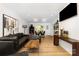 Open living space featuring a black leather sofa, modern decor, and access to the dining area at 6824 Cortez Trl, Charlotte, NC 28227