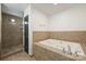 Bathroom featuring a soaking tub and separate tiled shower, designed for relaxation and comfort at 715 N Graham St # 603, Charlotte, NC 28202