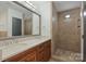 Bathroom with double sink vanity, large mirror, and tiled walk-in shower at 715 N Graham St # 603, Charlotte, NC 28202
