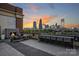 The Garrison at Graham roof deck featuring an outdoor fireplace, lounge area, and bar with stunning city views at 715 N Graham St # 603, Charlotte, NC 28202