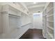 A spacious walk-in closet with ample built-in shelving and storage options and hardwood floors at 715 N Graham St # 603, Charlotte, NC 28202