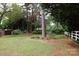 Spacious backyard featuring mature trees, green grass, and a white picket fence at 723 Rabun Ln, Rock Hill, SC 29730