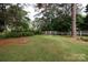 A shot of the backyard featuring a green lawn, mature trees, and a white picket fence at 723 Rabun Ln, Rock Hill, SC 29730