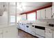 Well-lit kitchen with white cabinets, brick backsplash, and modern appliances at 723 Rabun Ln, Rock Hill, SC 29730