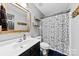 Bathroom with a shower, vanity, framed mirror, and wall mounted shelving at 7321 Mapleridge Dr, Charlotte, NC 28210