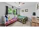 Bright bedroom features two twin beds, a ceiling fan, and a large window offering natural light at 7321 Mapleridge Dr, Charlotte, NC 28210