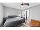Comfortable bedroom features a ceiling fan, wood floors, and a gray and white color palette at 7321 Mapleridge Dr, Charlotte, NC 28210