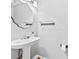 Powder room with pedestal sink, decorative mirror, and modern fixtures for added convenience at 7321 Mapleridge Dr, Charlotte, NC 28210