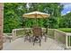 Outdoor dining area on the deck with seating for four and a large umbrella at 7501 Cleyera Cir, Waxhaw, NC 28173