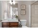 Bright bathroom featuring a wooden vanity with white countertop and decorative starfish and sand dollar wall art at 7501 Cleyera Cir, Waxhaw, NC 28173