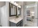 Well-lit bathroom featuring a vanity with a dark frame mirror and a shower with white curtains at 7501 Cleyera Cir, Waxhaw, NC 28173
