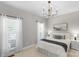 Comfortable bedroom with neutral tones, white bedding, carpet flooring, and a window providing natural light at 7501 Cleyera Cir, Waxhaw, NC 28173