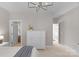 Bright bedroom with neutral colors, a white dresser, carpeted floors, and multiple doorways leading to other areas at 7501 Cleyera Cir, Waxhaw, NC 28173