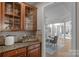 Transitional-style dining area with white table and gray chairs, connecting to a kitchen with wooden cabinetry and granite counters at 7501 Cleyera Cir, Waxhaw, NC 28173
