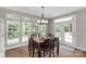 Bright dining room with a wood table, black chairs, hardwood flooring, and large windows offering an outdoor view at 7501 Cleyera Cir, Waxhaw, NC 28173