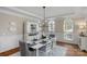 Bright and elegant dining room with wainscoting, white table setting, a modern chandelier, and large arched windows at 7501 Cleyera Cir, Waxhaw, NC 28173