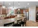 Spacious kitchen with granite countertops, wooden cabinets, stainless steel appliances, and a central island with barstool seating at 7501 Cleyera Cir, Waxhaw, NC 28173