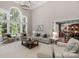 Spacious living room with large windows, a soaring ceiling, and stylish, neutral-toned furniture at 7501 Cleyera Cir, Waxhaw, NC 28173