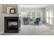 Cozy living room featuring a black fireplace, plush blue armchairs, and ample natural light from large windows at 7501 Cleyera Cir, Waxhaw, NC 28173