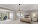 Spacious main bedroom featuring neutral tones, tray ceiling, decorative chandelier and sitting area with lots of windows at 7501 Cleyera Cir, Waxhaw, NC 28173