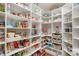 Organized walk-in pantry with white shelving stocked with an assortment of food items and kitchen appliances at 7501 Cleyera Cir, Waxhaw, NC 28173