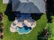 Aerial view of a home showcasing a backyard oasis with pool, patio, deck, and lush landscaping at 7507 Meadowgate Ln, Waxhaw, NC 28173